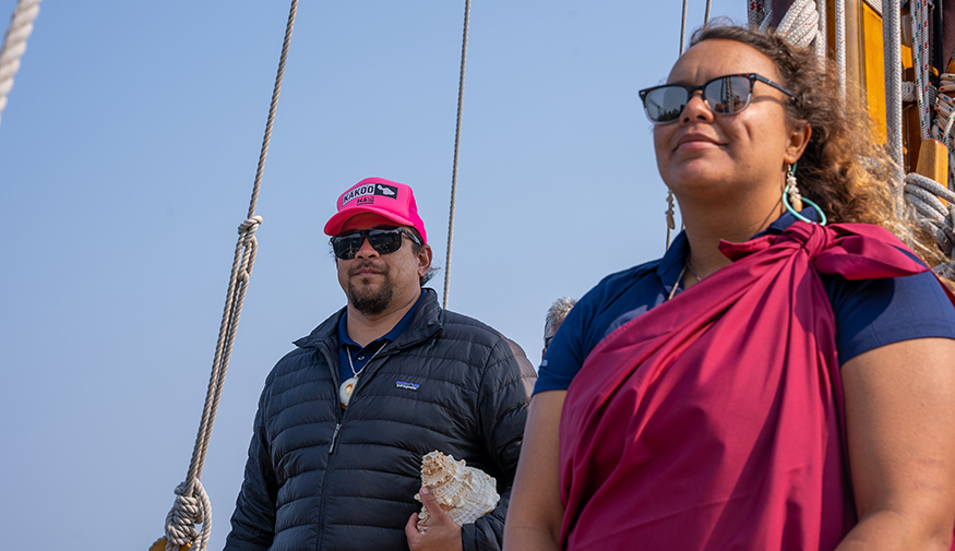 Brittany Kamai in sunglasses standing aboard boat with another crew member. 