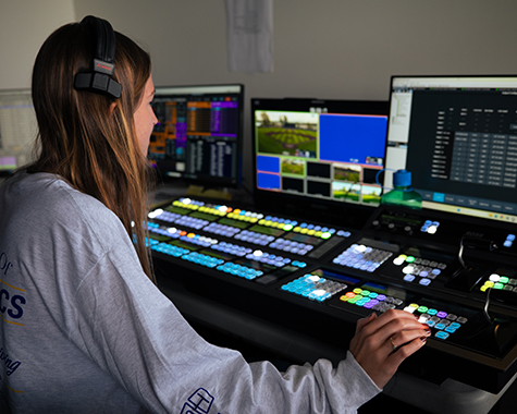 Audrey Spurgeon wearing a headset in a broadcast control room.