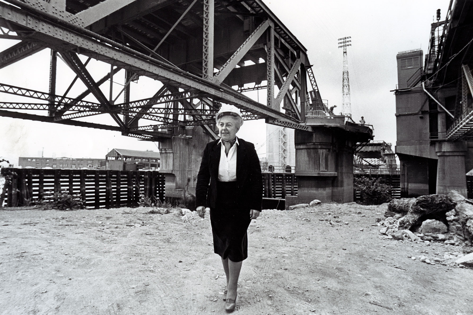 Black and white photo of Jeanette Williams in front of bridge construction.