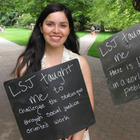 Law, Societies and Justice student holding a black sign with white text that reads "LSJ taught me to challenge the status quo through social justice oriented work"