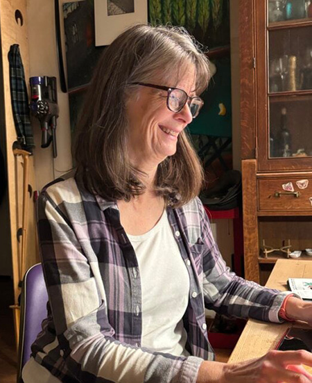 Mary Brunkow sitting at table in her home