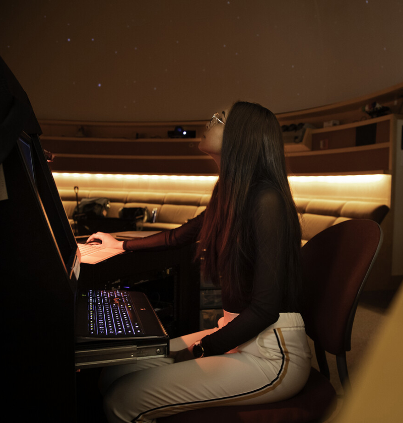A student operating the projector in the UW Planetarium