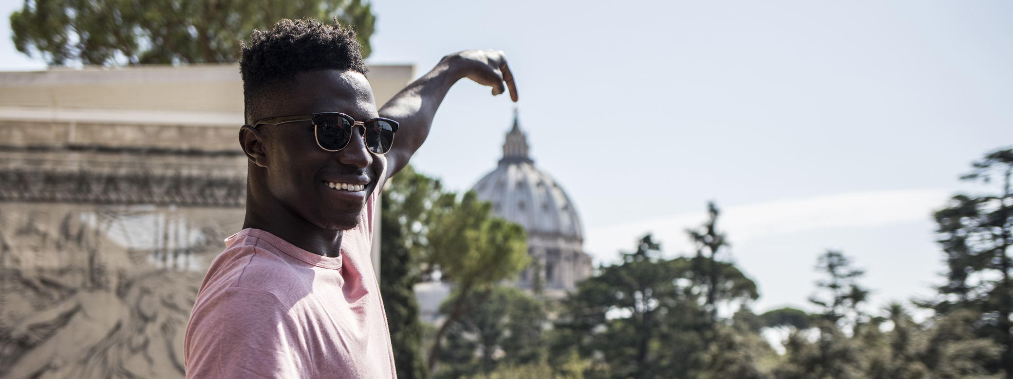 A student pointing at the top of the Vatican cathedral in Rome.