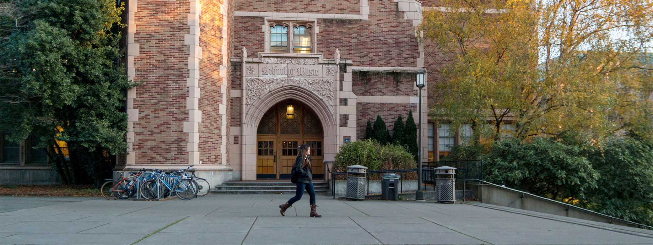 A student walking outside the entrance to the UW School of Music building.