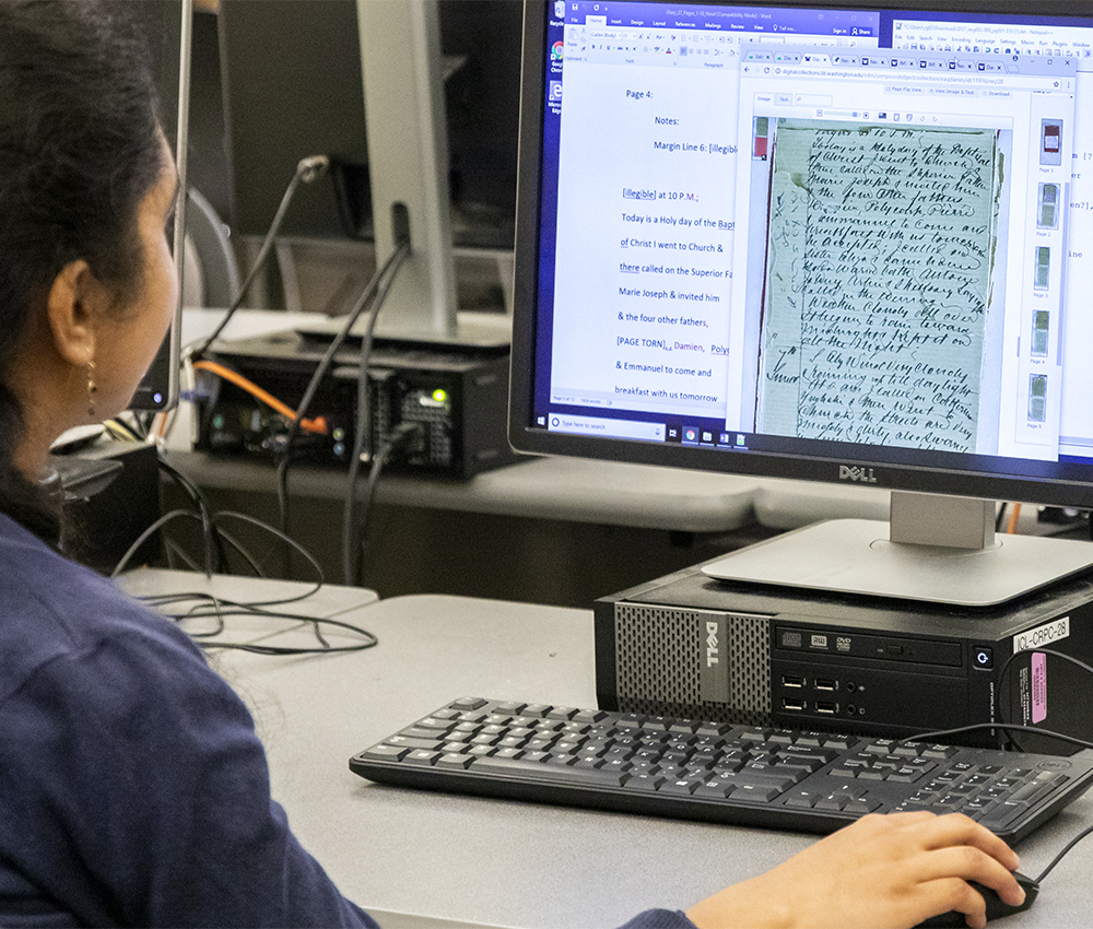 Student working on a computer analyzing a historic manuscript in the UW's Department of Near Eastern Languages and Civilization.