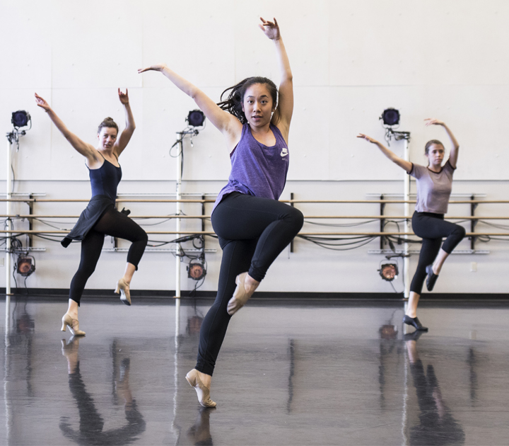 Three students practicing dance in a studio space.
