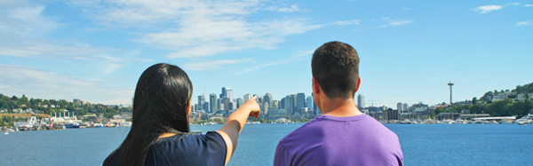 Two students look towards South Lake Union in downtown Seattle from Gas Works Park.
