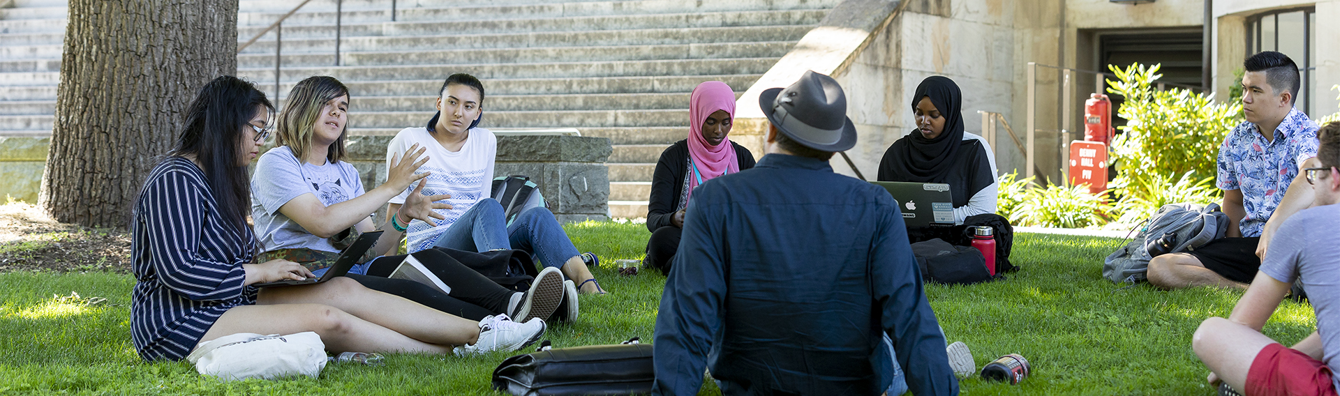 Students sitting outside on grass