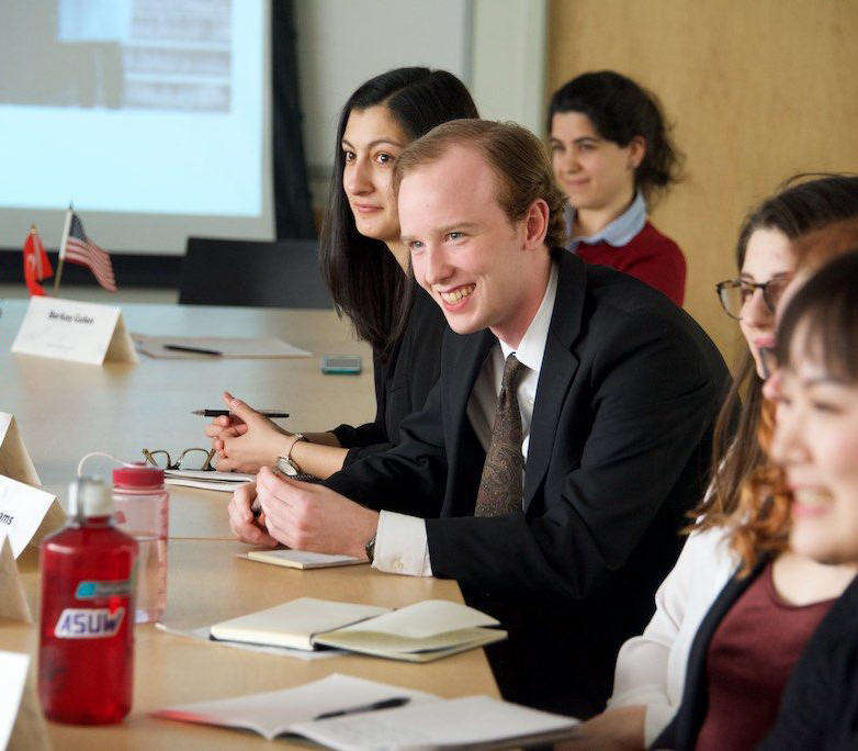 Students sit along a table in a discussion about the Jackson School's Task Force program.