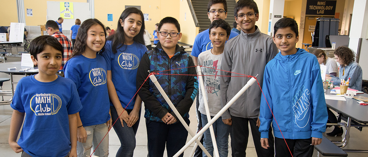 Young students posing with structure with poles created as a Pi Day challenge