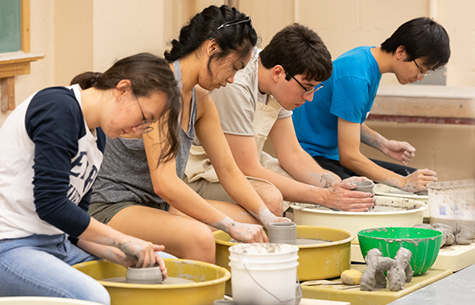 Students in a pottery class, using pottery wheels