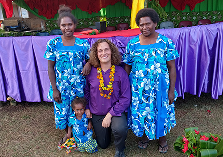 Jacob Ball in Vanuatu with a teacher and principal on either side in bright dresses.