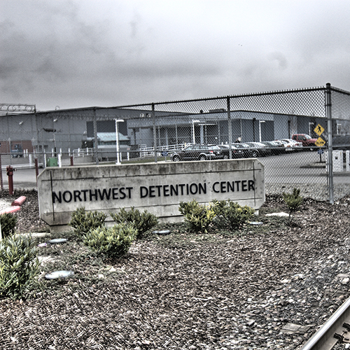 Outside Northwest Detention Center, showing Center's sign