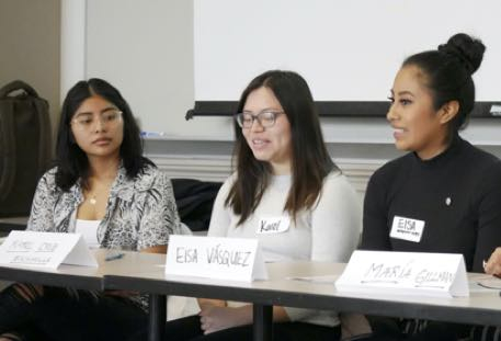 UW student panelists sitting at a table during a meeting