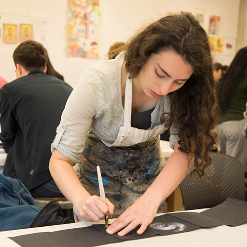 Student in studio, working on an art book