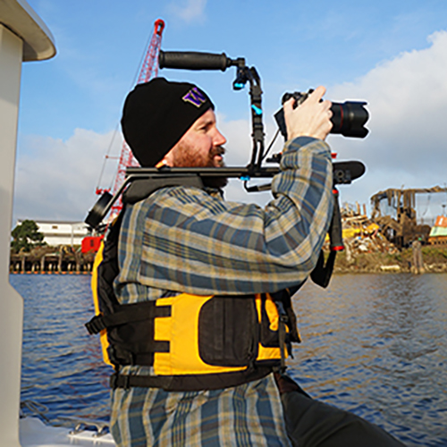 Student filming video from a boat