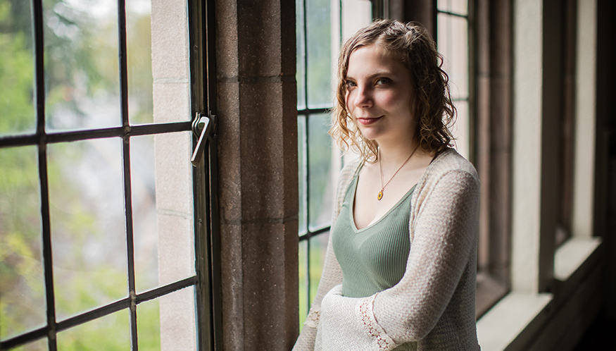 Darby Sherwood stands by a window in UW's Hutchinson Hall. 
