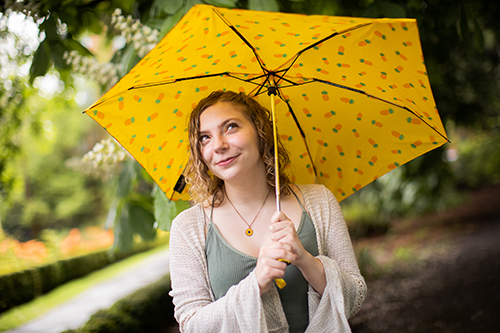 Darby Sherwood holding a yellow umbrella. 