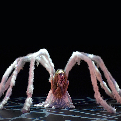 Momix performer sprouting legs like a giant spider.