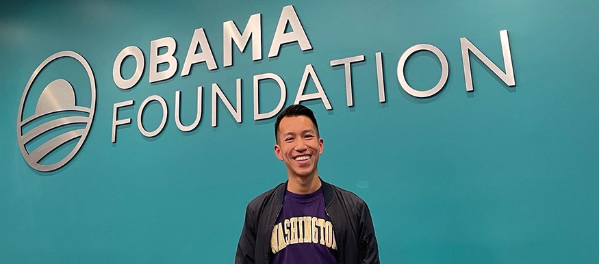 Simon Tran in front of Obama Foundation sing.