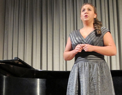 Voice student performing, with piano behind her.