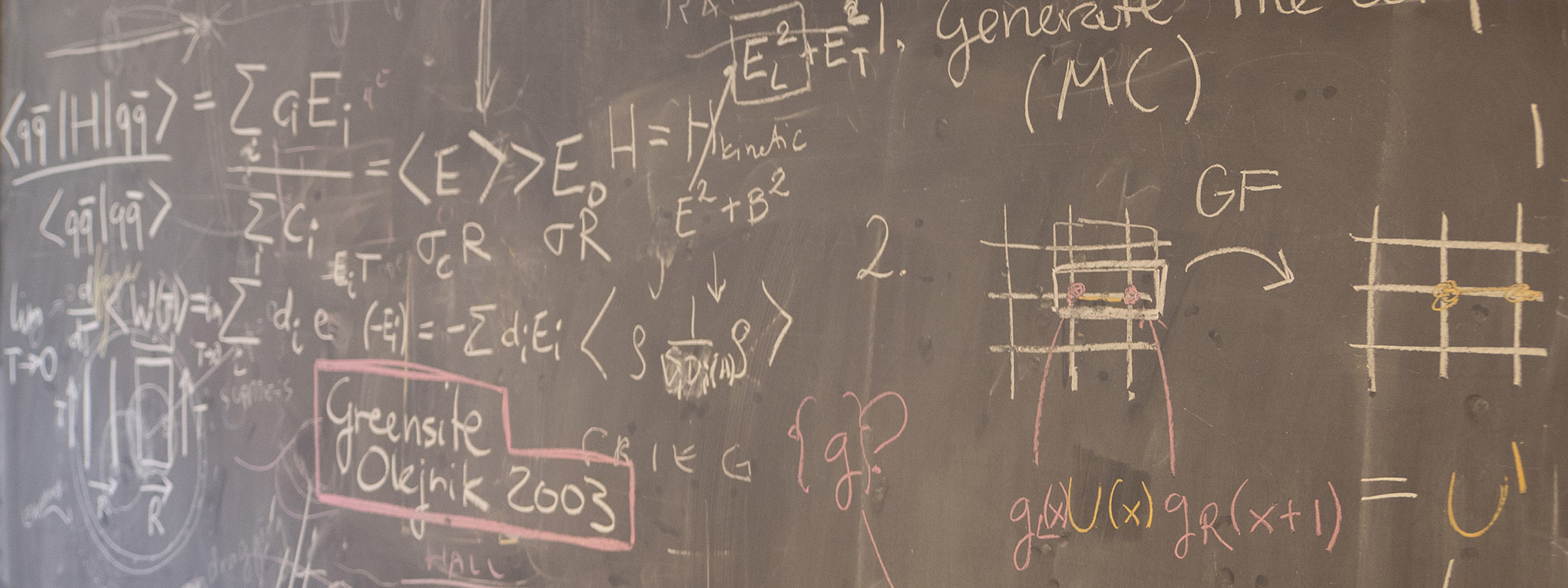 black chalkboard with physics notations scribbled across it