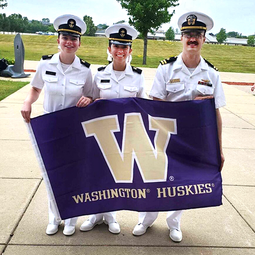 Navy ROTC students in uniform, holding UW banner.