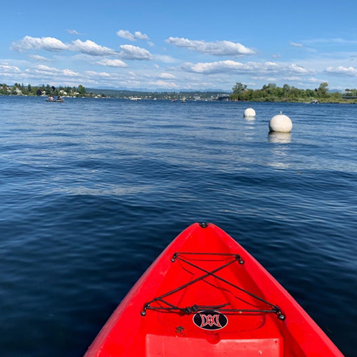 Front of a red kayak out on Lake Washington.