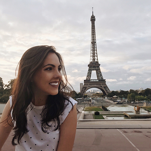 Student smiling with Eiffel Tower in the background.