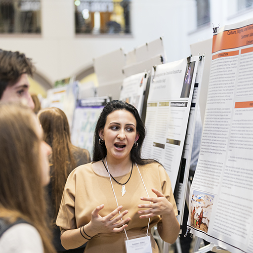 Students standing in front of research posters at Undergraduate Research Symposium.