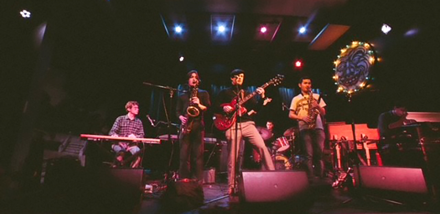 The band Joint Souls performing on stage, with four of the musicians visible at the front of the stage