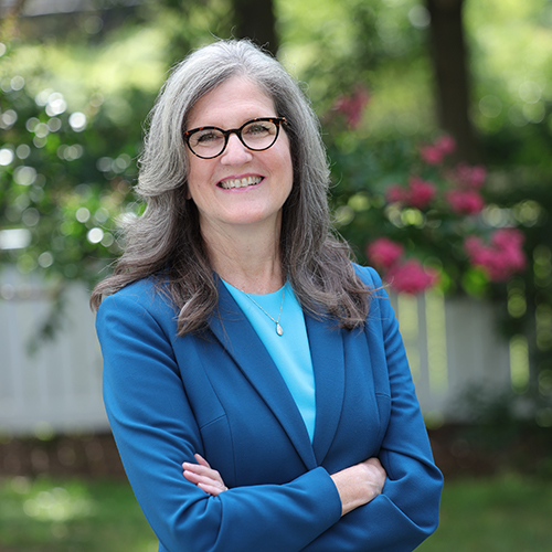 Portrait of Dianne Harris in suit, standing with arms crossed