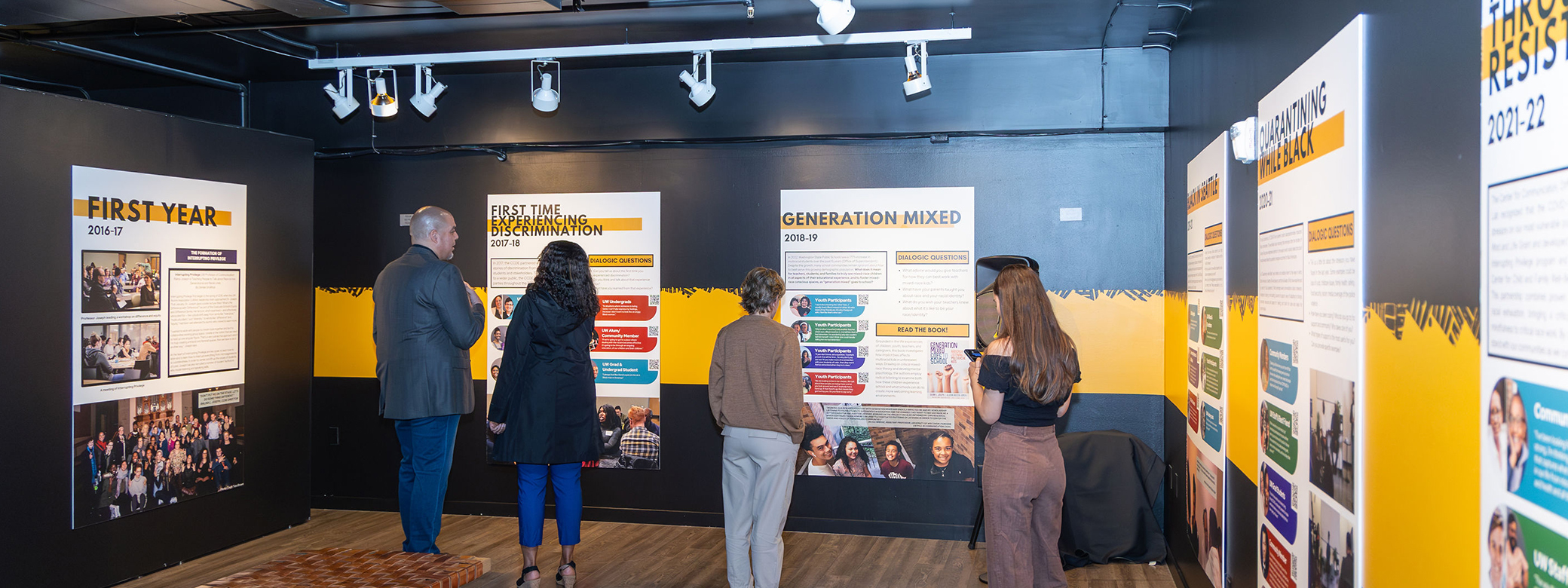 Visitors to the Northwest African American Museum looking at panels that are part of the Interrupting Privilege exhibit. 