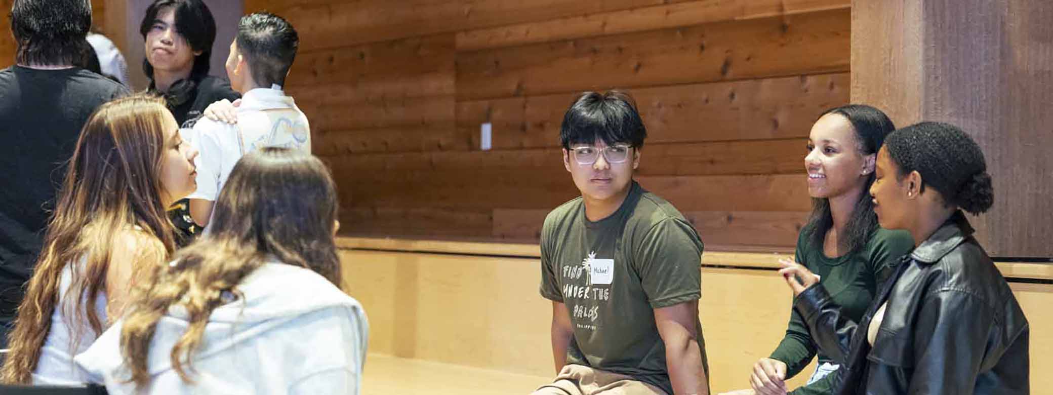 Five College Edge students talk in a meeting room.