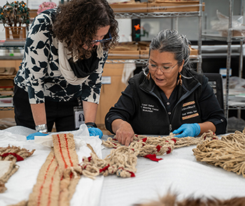 A faculty member and student looking at woven materials. 