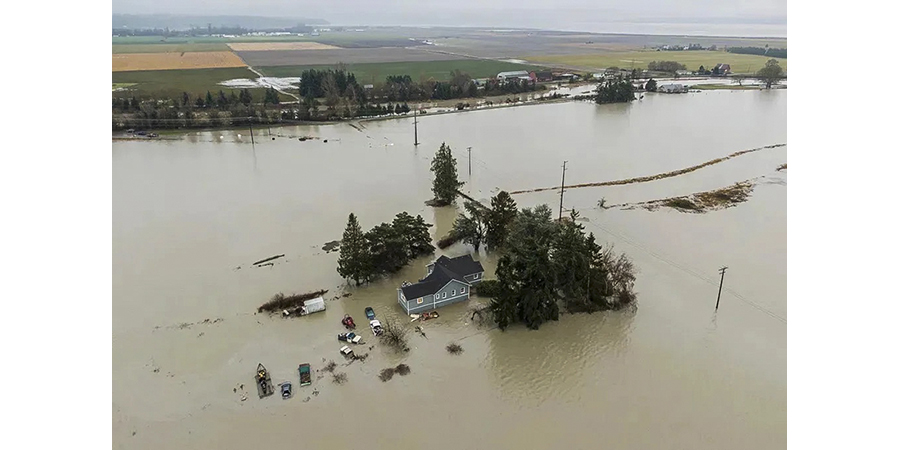 A drone view of house partially submerged by a flooded river. 