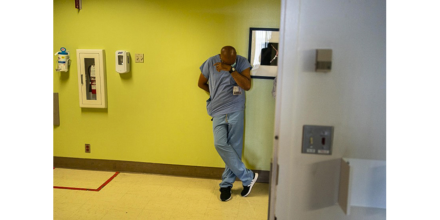 A nurse standing in a hospital hallway during Covid. 