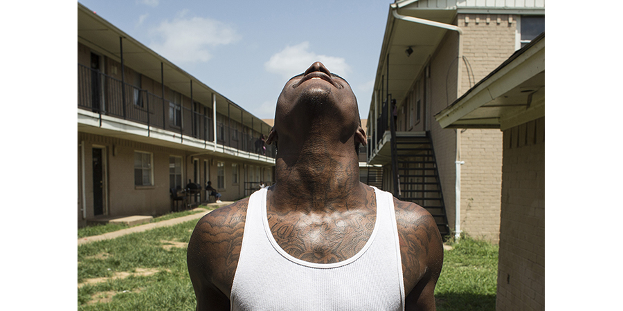 A tattooed man looking skyward.