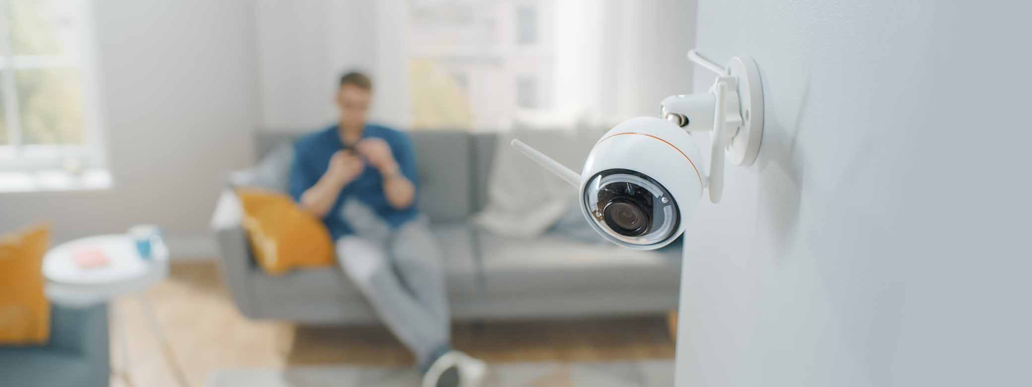 A living room with a home surveillance camera in the foreground.