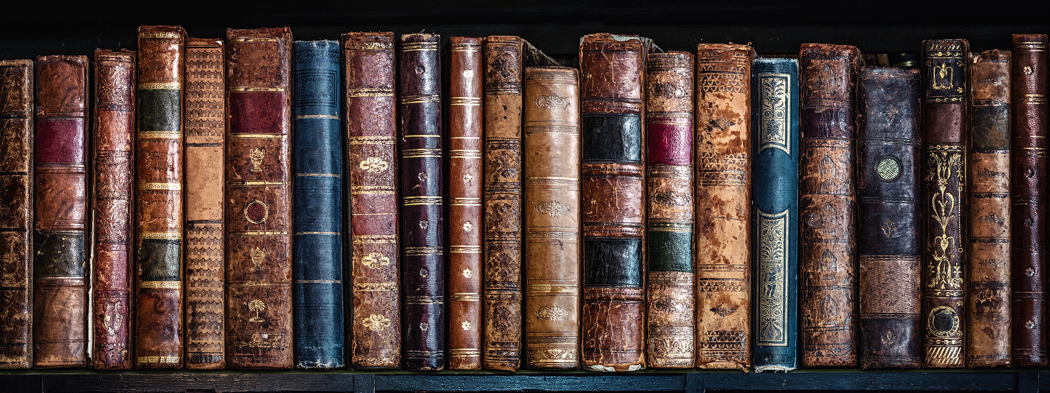 bookshelf filled with old leather-bound books. 