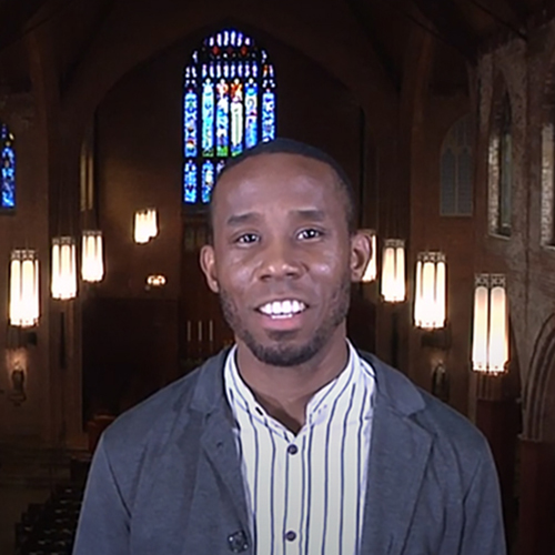 Professor Stephen Price, with stained glass window behind him.