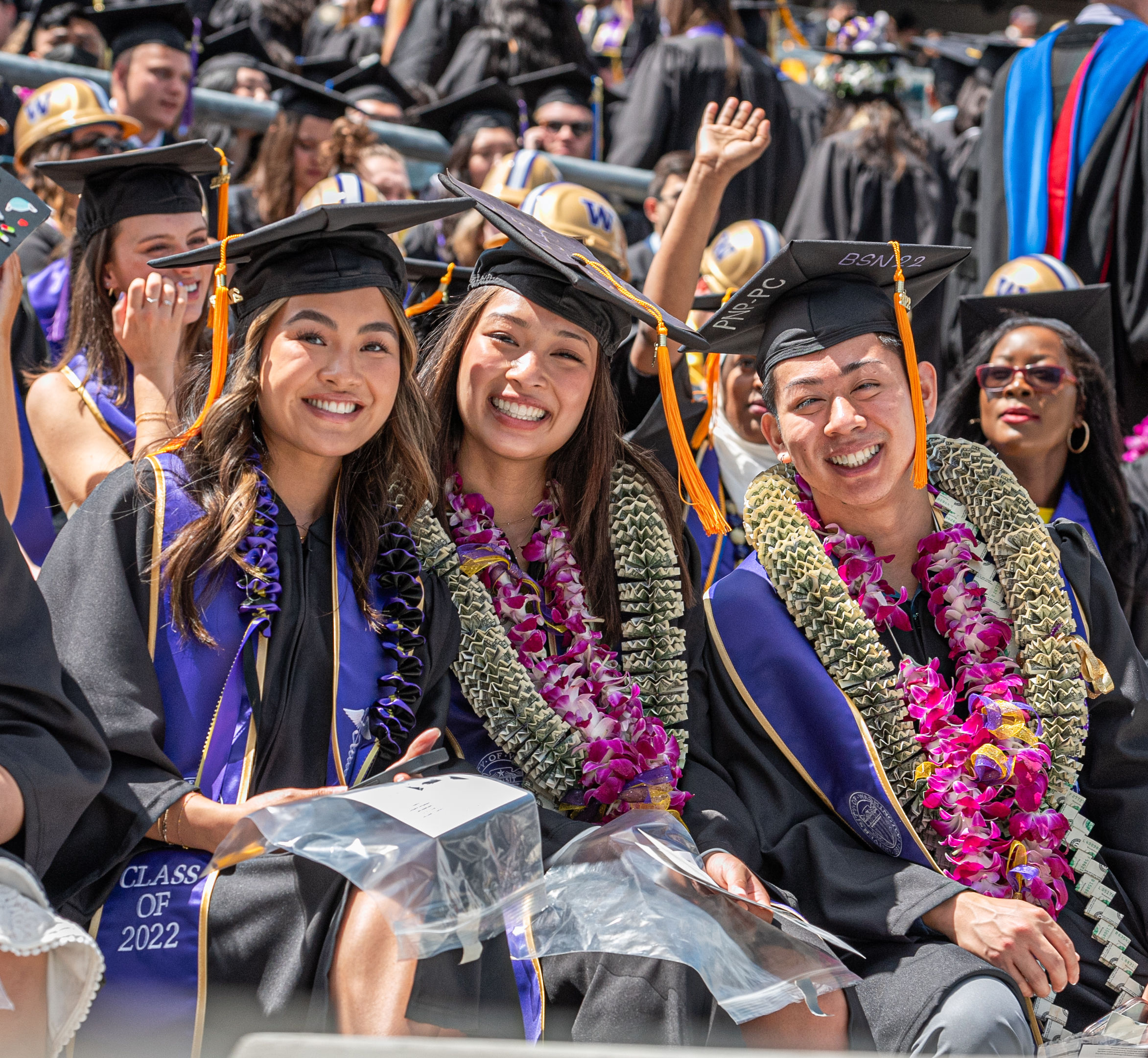 Graduating students sitting in cap and gown.