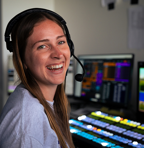 Audrey Spurgeon wearing a headset in a broadcast control room.