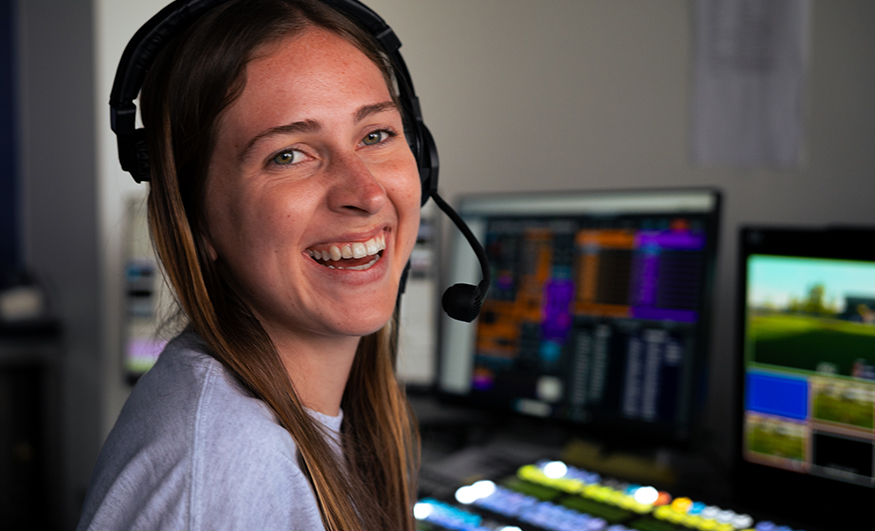 Audrey Spurgeon wearing a headset in a broadcast control room.