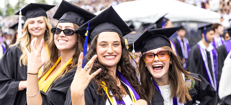 UW Commencement, students in cap and gown smiling.