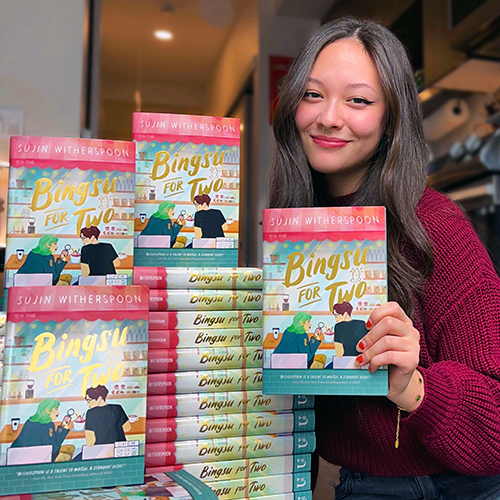 Sujin Witherspoon with a pile of copies of her book, Bingsu for Two.