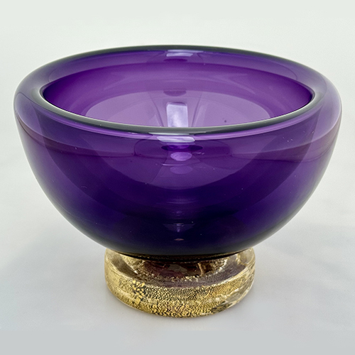 purple bowl made of blown glass, with a gold-flecked base
