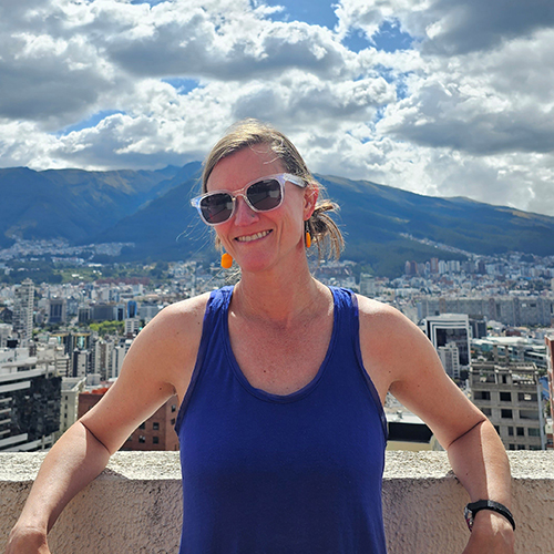 Rebecca Beard in Quito, Ecuador, with the city and mountains in the background behind her.