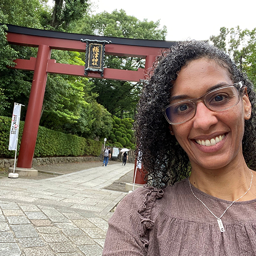 Christina Sunardi with a tall Japanese gate structure in the background.