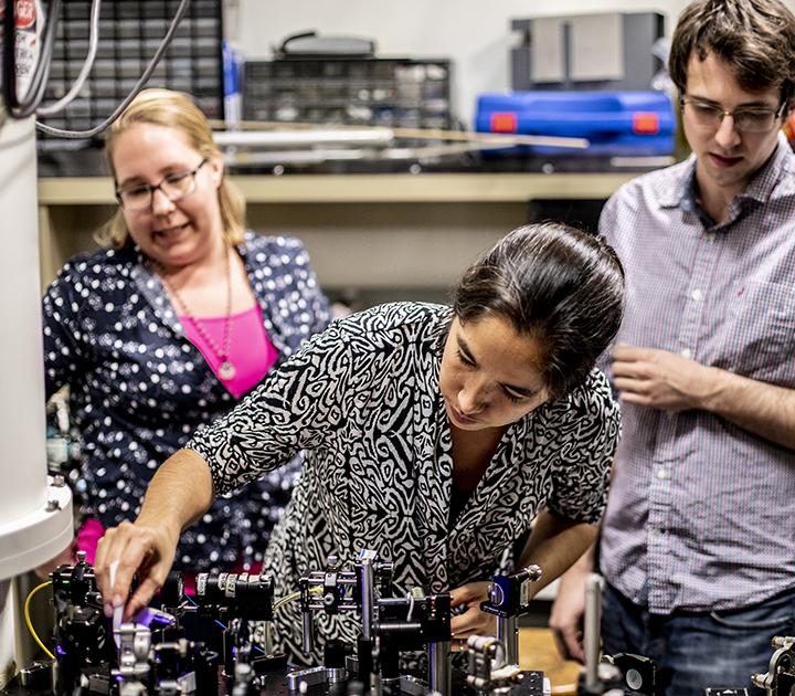 Kai-Mei Fu working adjusting equipment for an quantum experiment in a UW lab. 